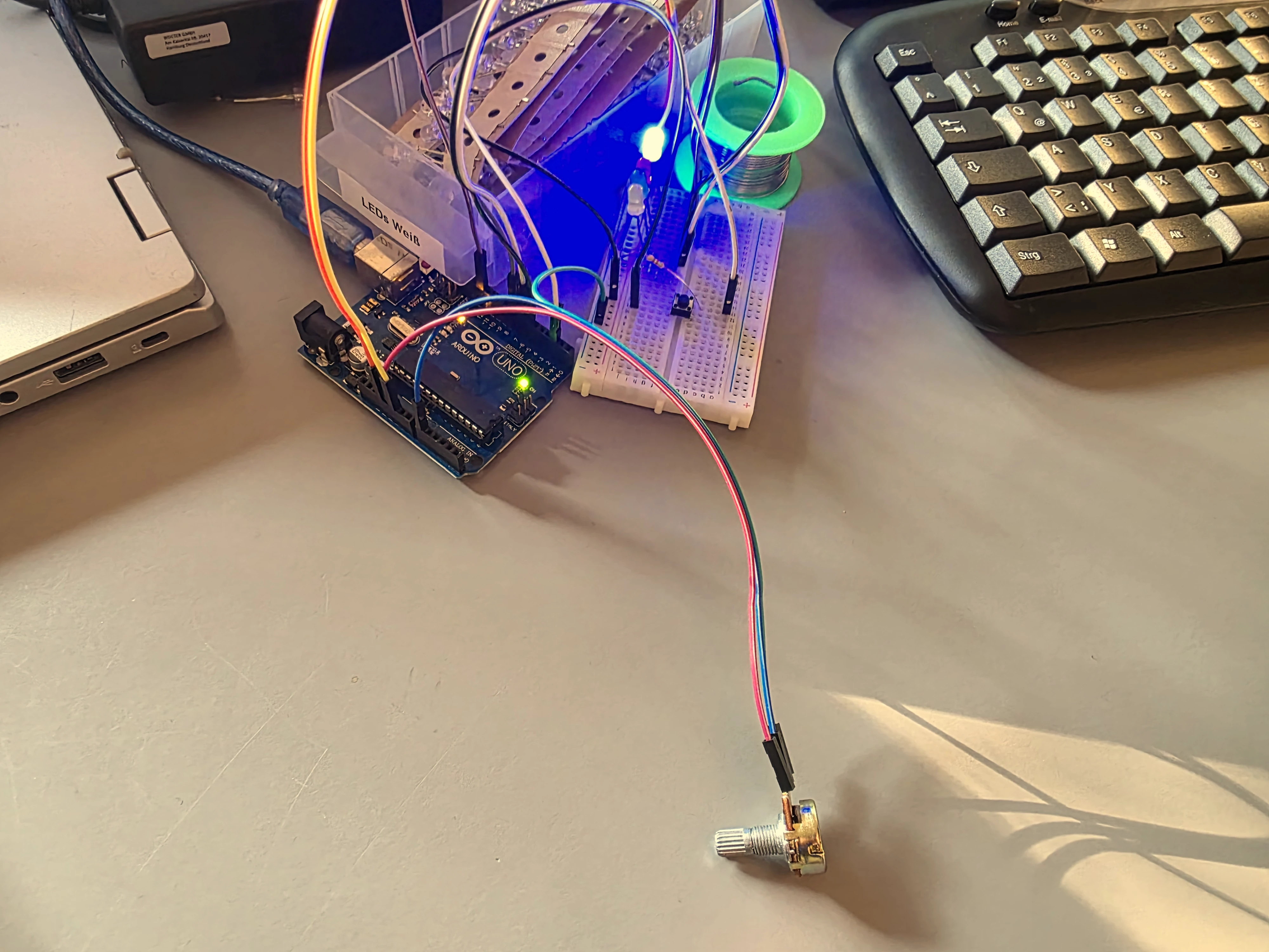 Ein Arduino UNO Mikrocontroller, an welchen ein Potentiometer, vier LEDs und ein Knopf angeschlossen ist